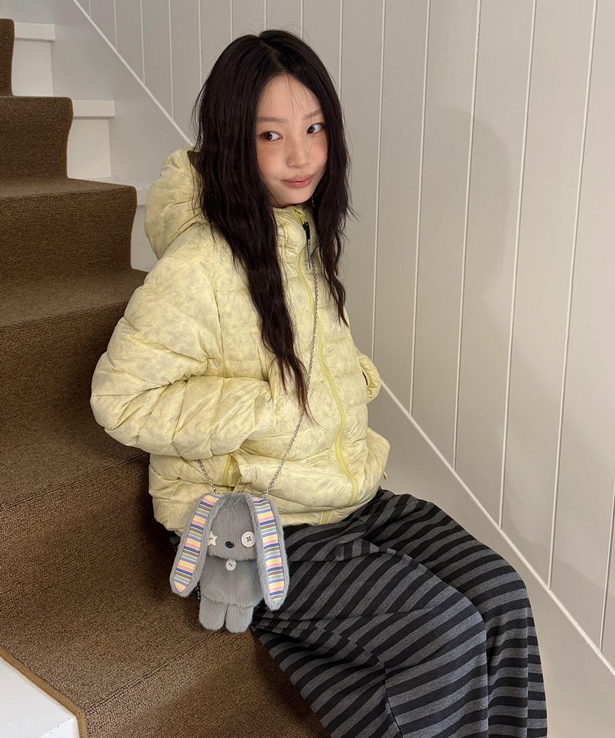 가을 분위기 물씬 나는 카페 테라스 의자에 카비시 버터 크림 자켓을 자연스럽게 걸쳐둔 모습