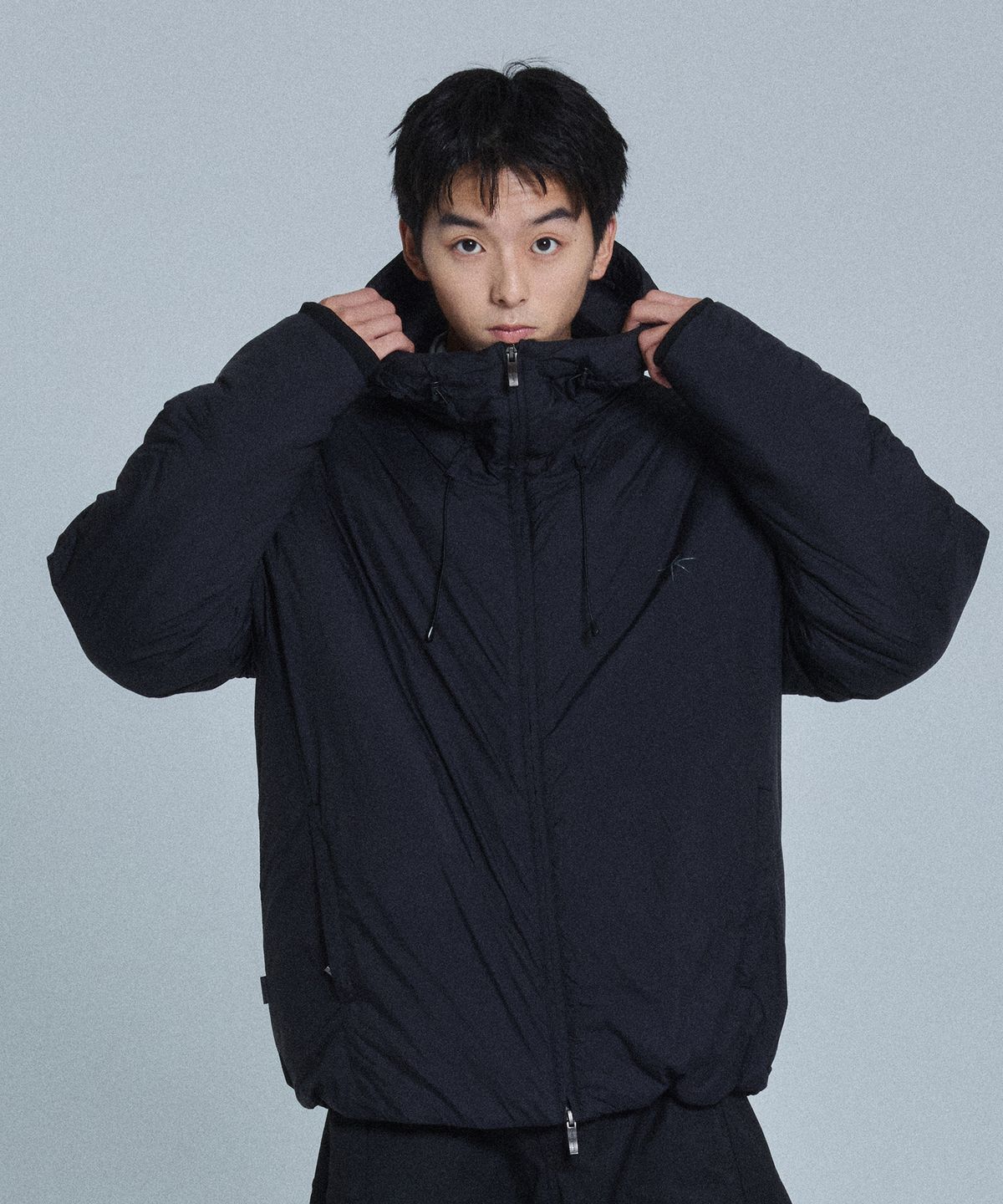 깔끔하게 포장된 노드랩스 패딩 자켓을 선물 상자에서 꺼내며 동생에게 전달하는 모습