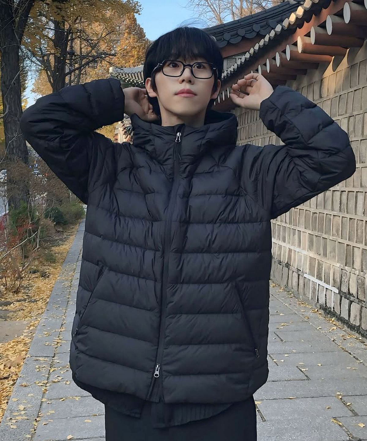 패딩 자켓을 펼쳐놓고 전체적인 실루엣과 후드 부분을 상세히 보여주는 컷