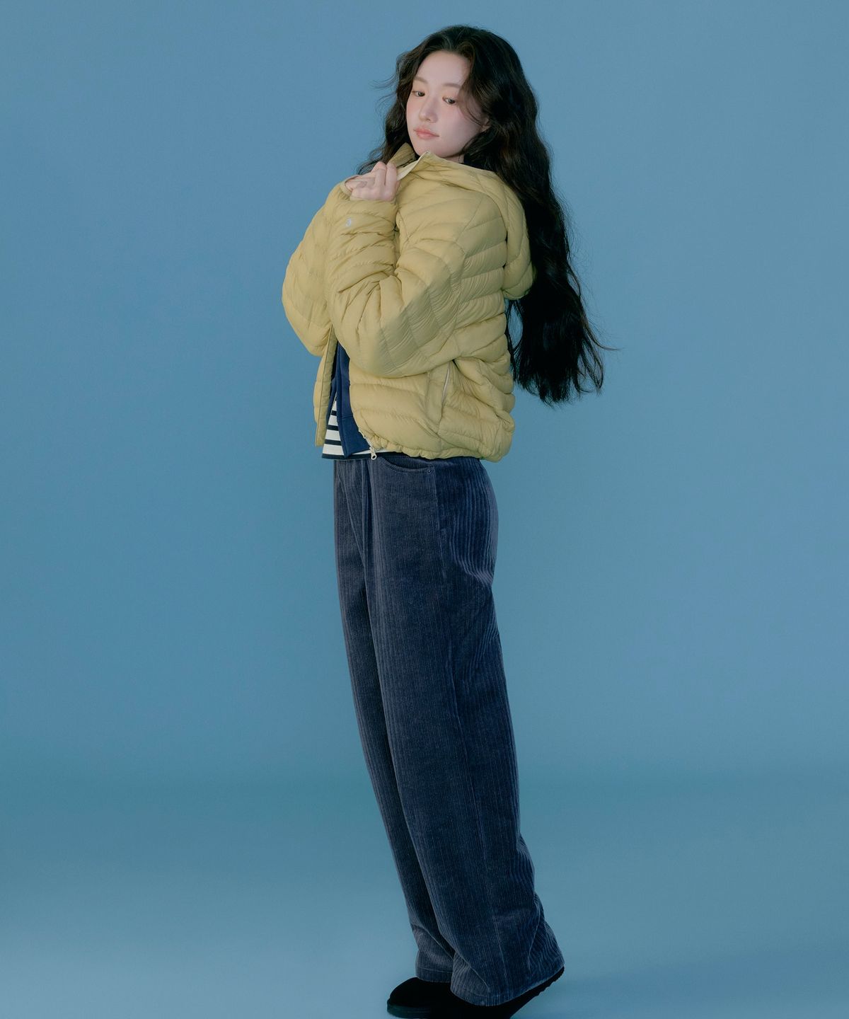바람 부는 날 자켓의 일체형 후드를 쓰고 지퍼를 끝까지 올린 클로즈업 샷