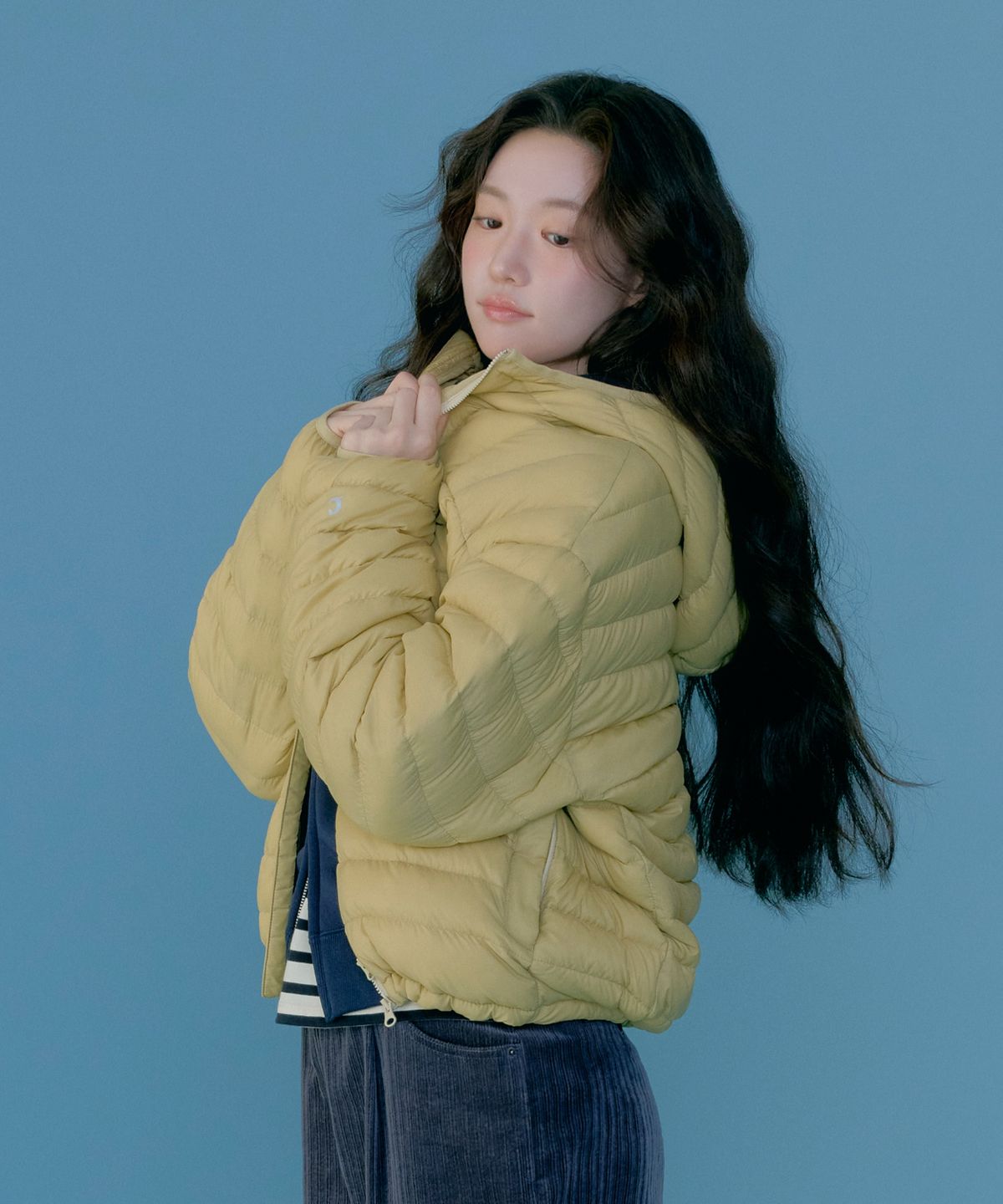 봉제선 사이로 아주 미세하게 튀어나온 다운 털 한 가닥을 보여주는 솔직한 접사
