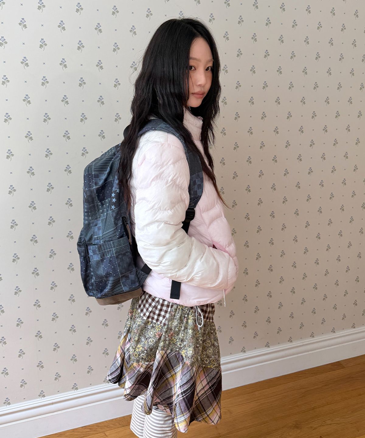 카페 의자에 패딩을 걸쳐두었을 때 자연스럽게 잡히는 구김과 핑크색 원단의 부드러운 광택이 보이는 사진