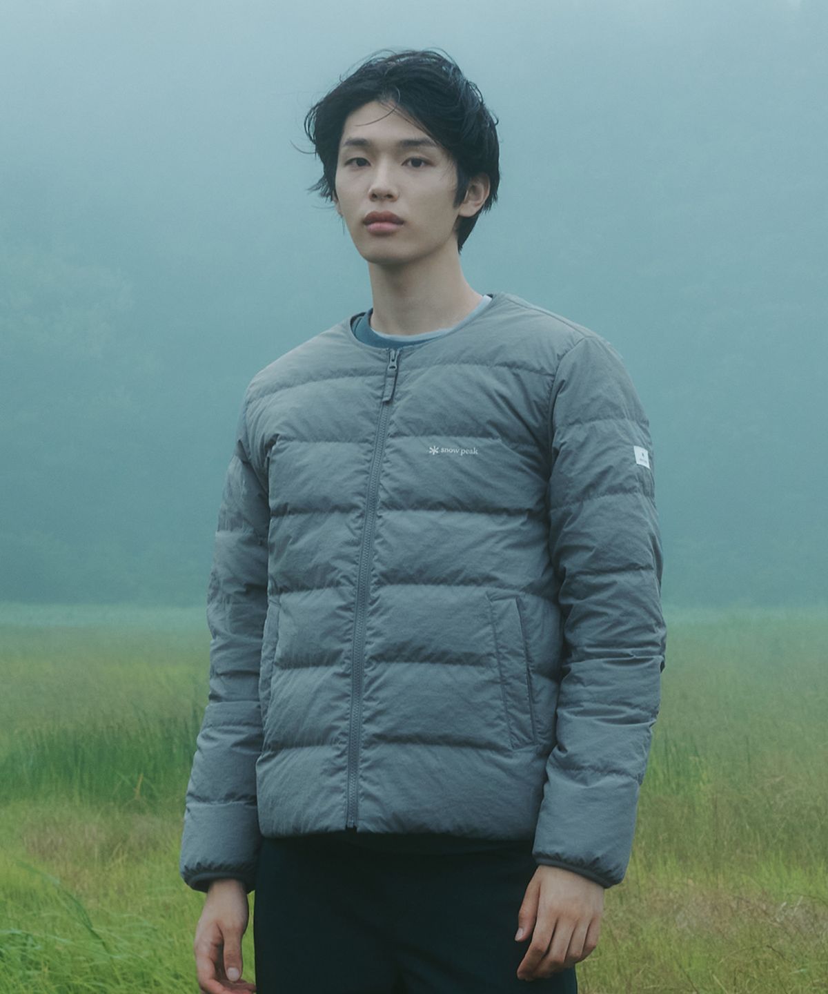 산책 중에 벤치에 앉아 자켓의 가벼움을 보여주기 위해 한 손으로 옷을 가볍게 든 모습