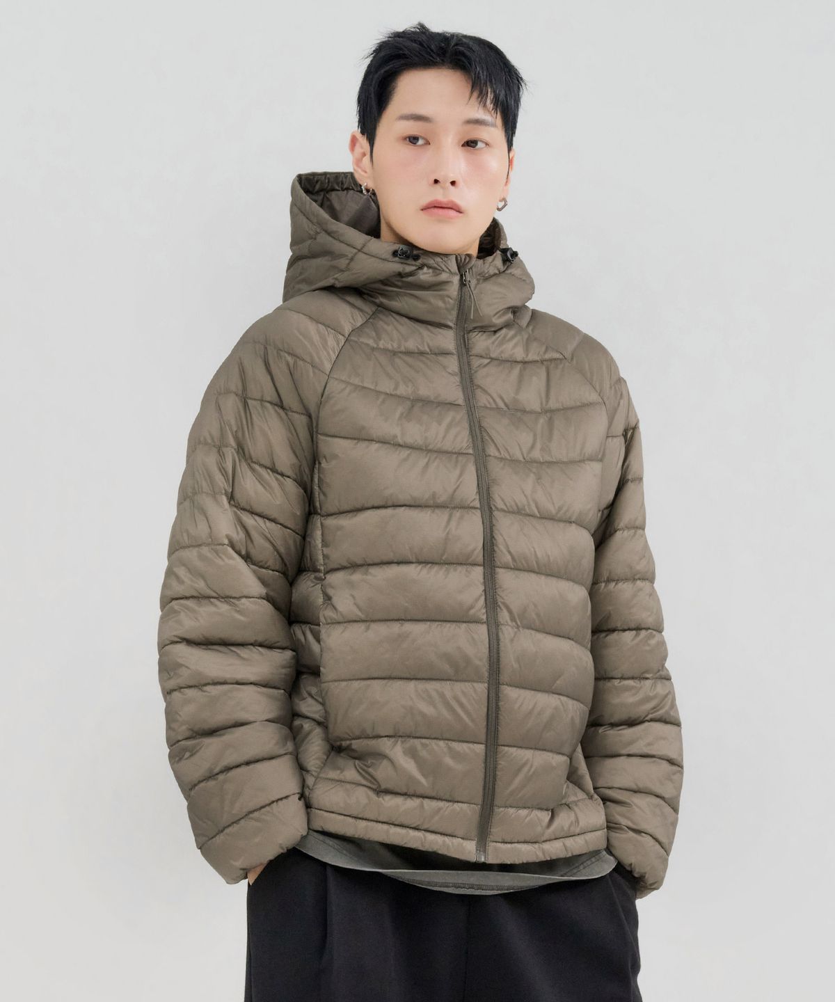 바람 부는 야외 공원에서 후드를 쓰고 산책하는 모습, 방풍 기능을 체감하는 장면