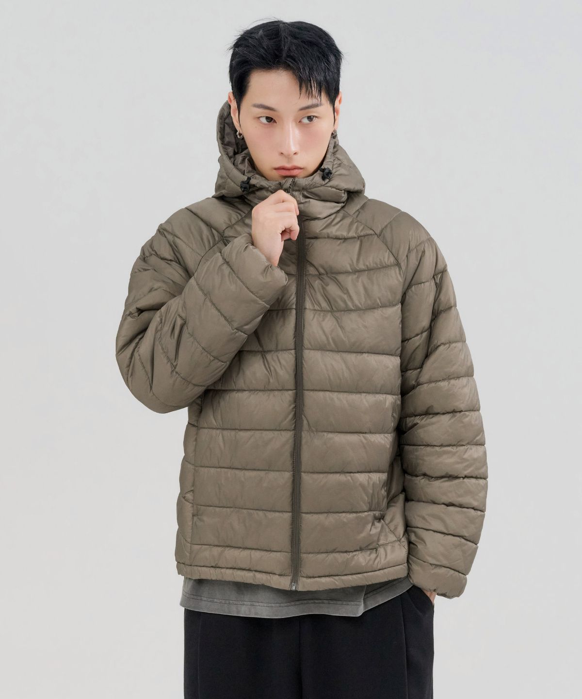 지하철 역 안에서 패딩을 가볍게 팔에 걸치고 이동하는 일상적인 모습