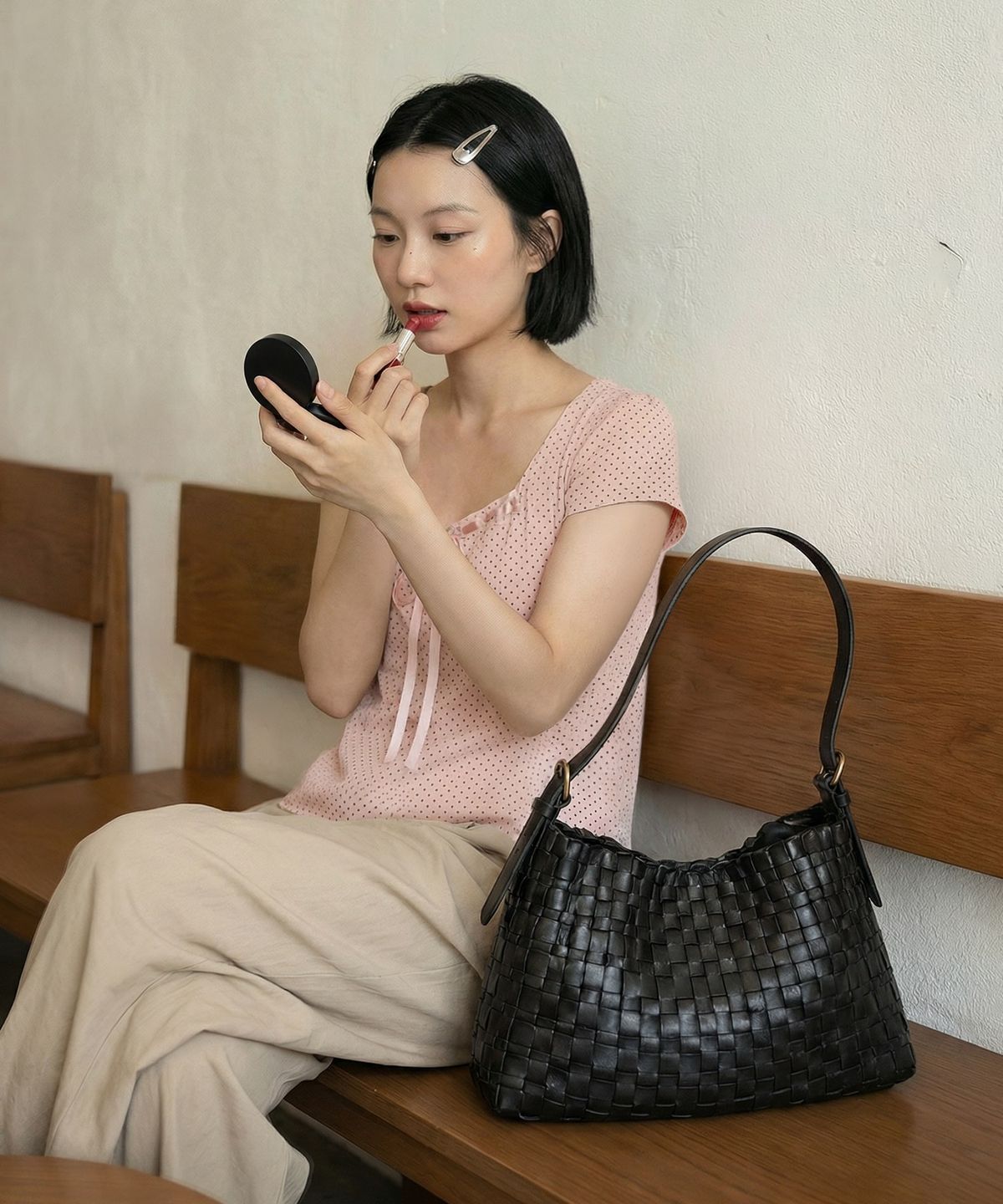 가을 햇살 아래 블랙 호보백을 어깨에 메고 자연스럽게 서 있는 전신 착용 샷